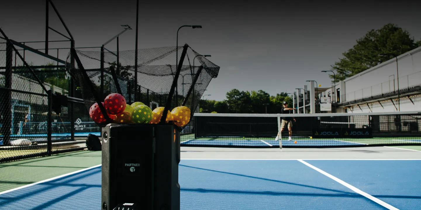 Tennibot Station and Rover tennis ball machines on the court