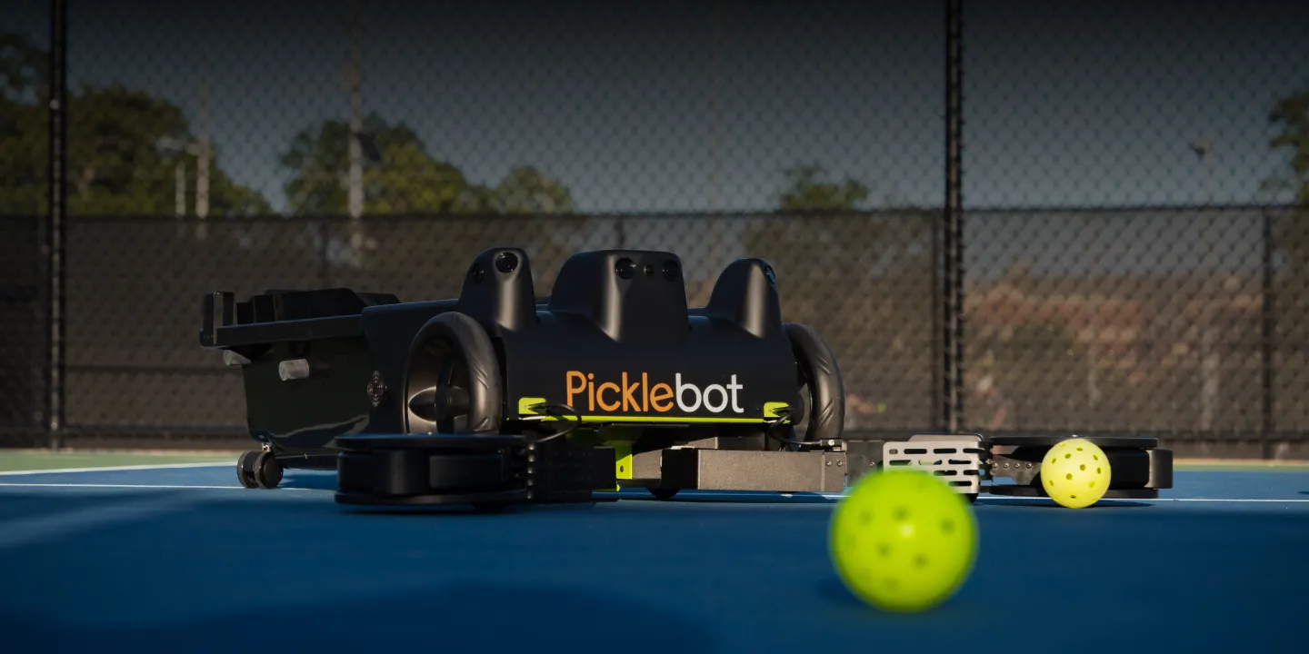 Tennibot Station and Rover tennis ball machines on the court