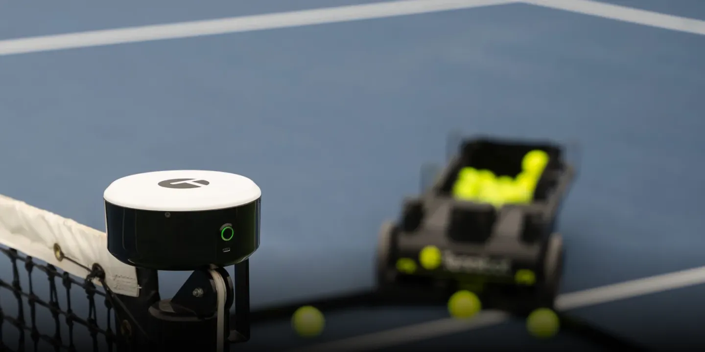 Tennibot Station and Rover tennis ball machines on the court